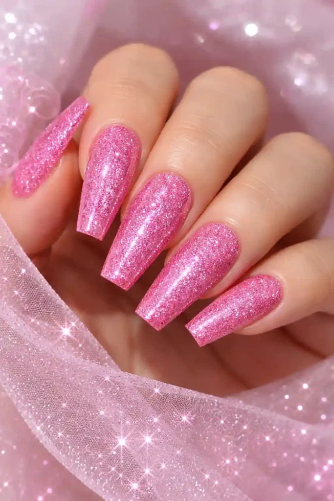 Pink glitter coffin nails with shimmering rose-tinted micro-glitter over a bubblegum base
