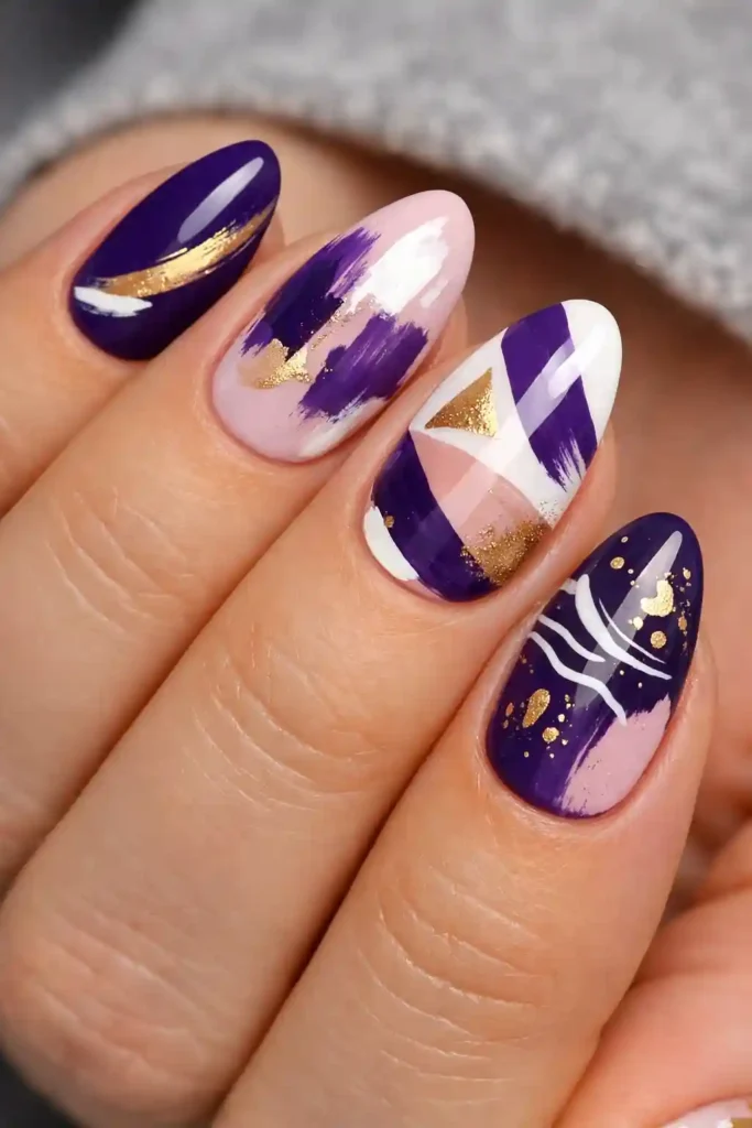 Purple abstract nails with bold brushstroke nail art in violet and gold on nude base