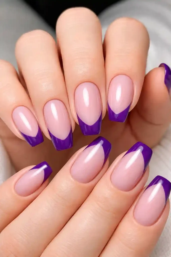 Purple French tip nails with deep violet tips on sheer nude base on almond nails