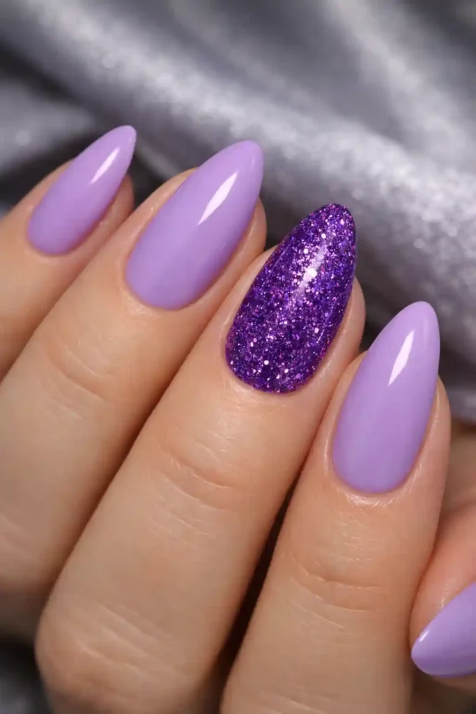 Purple glitter accent nails with lilac base on almond shaped nails