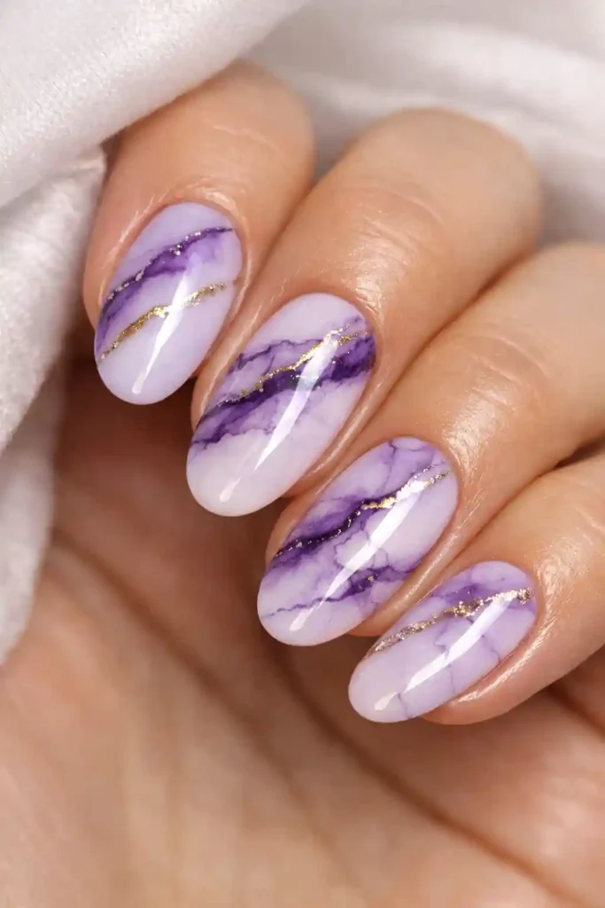 Purple marble nails with deep purple veining on pale lilac base with glossy finish