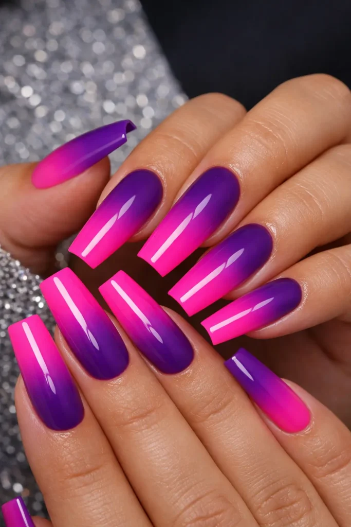 purple to pink ombre nails with deep violet fading into hot pink on long coffin nails
