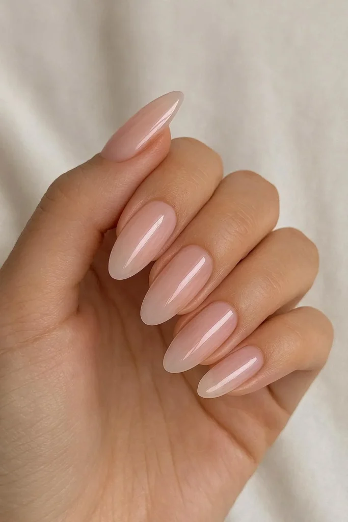 Sheer baby pink almond shaped acrylic nails with glossy finish