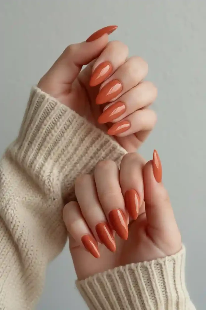 Short almond nails in warm terracotta burnt orange polish