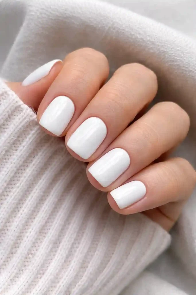 Short white nails with a clean glossy finish on short square rounded nails