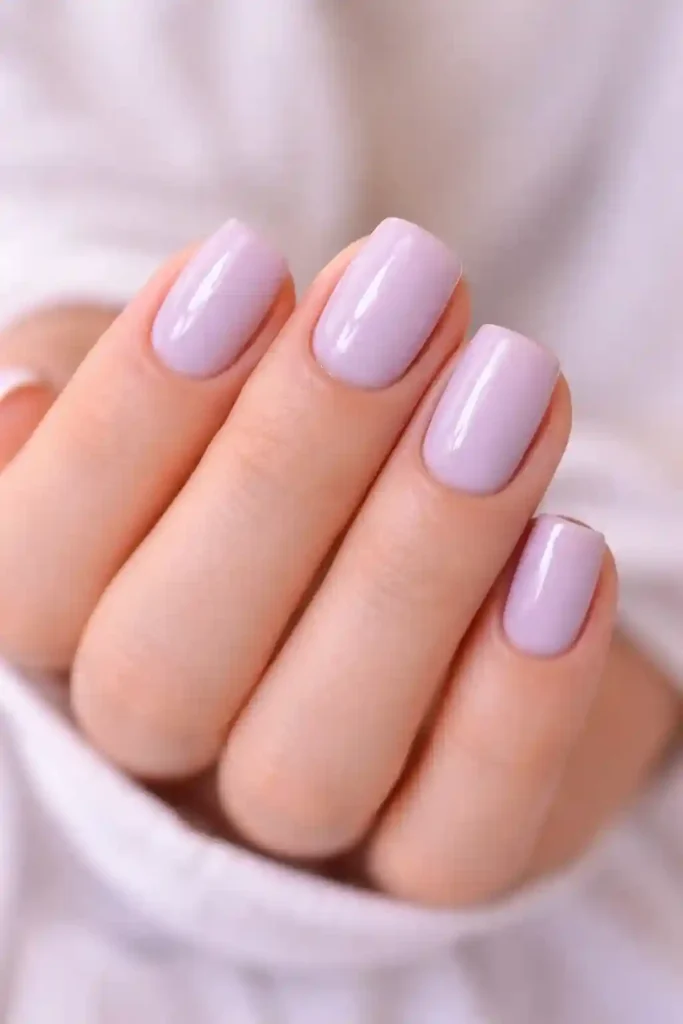 Soft lavender minimal nails with glossy finish on short oval shaped nails