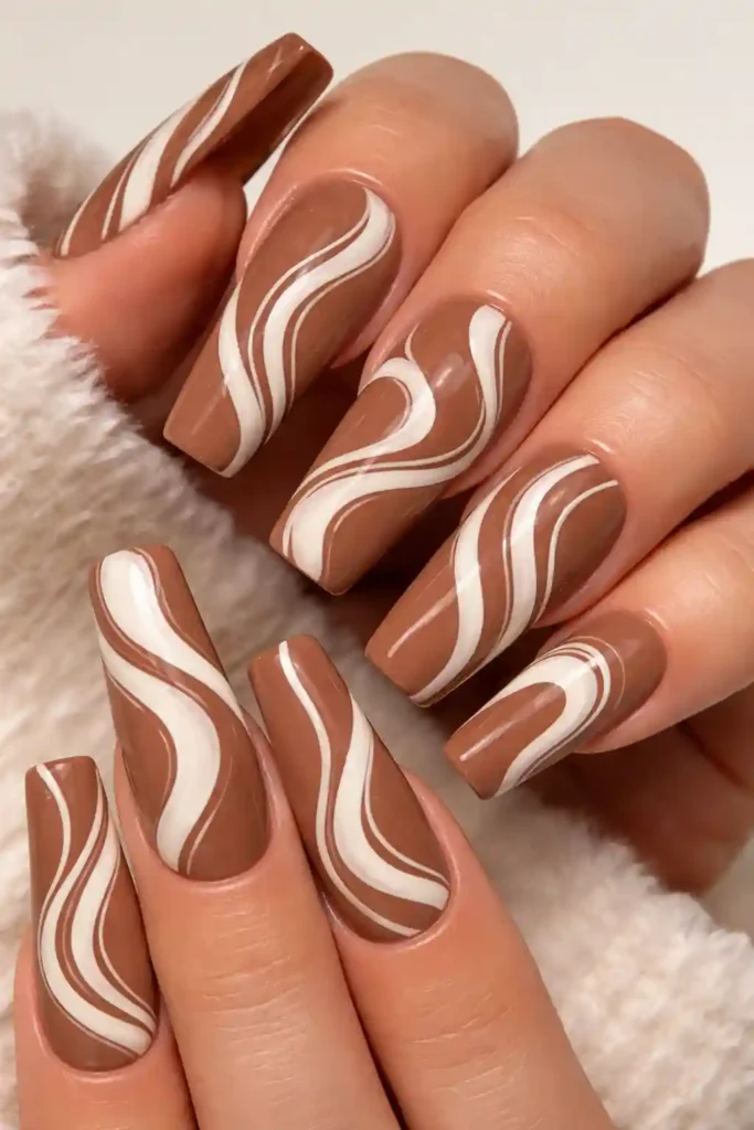 Abstract swirl coffin nails with cream and blush hand-painted swirls on a dark base