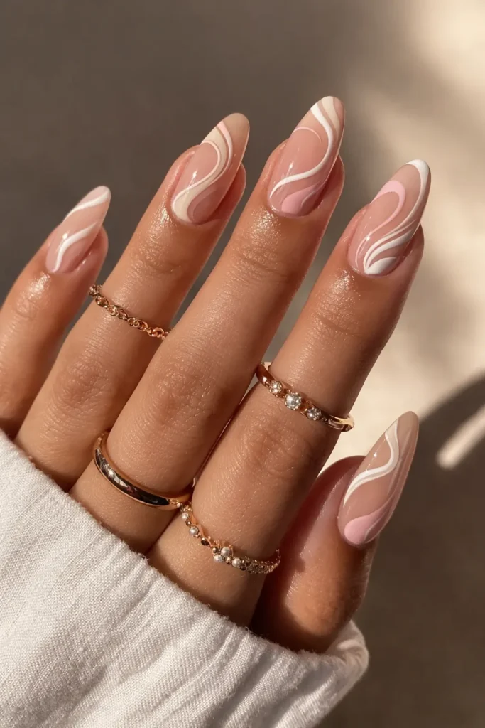 Swirl french tip nails with hand painted white cream swirl design on nude base almond nails