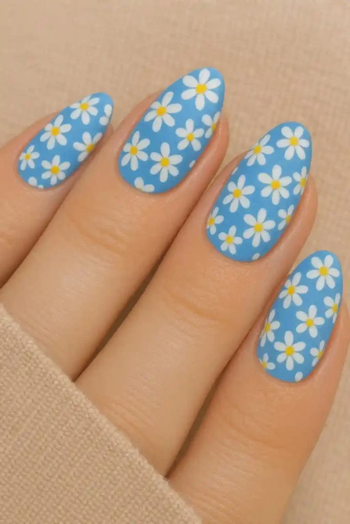 white daisy floral nail art on cerulean blue base with lemon yellow centers