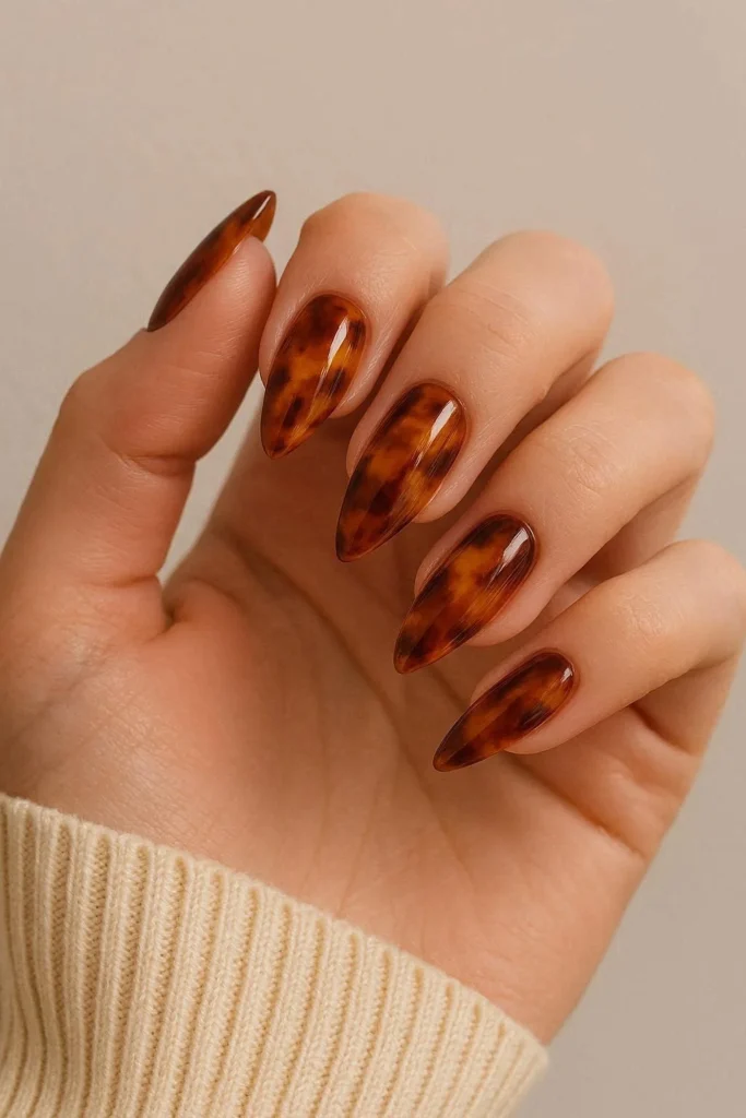 Tortoiseshell print almond acrylic nails in amber and caramel