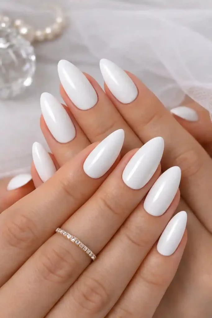 White almond nails with a glossy finish on long tapered almond-shaped nails