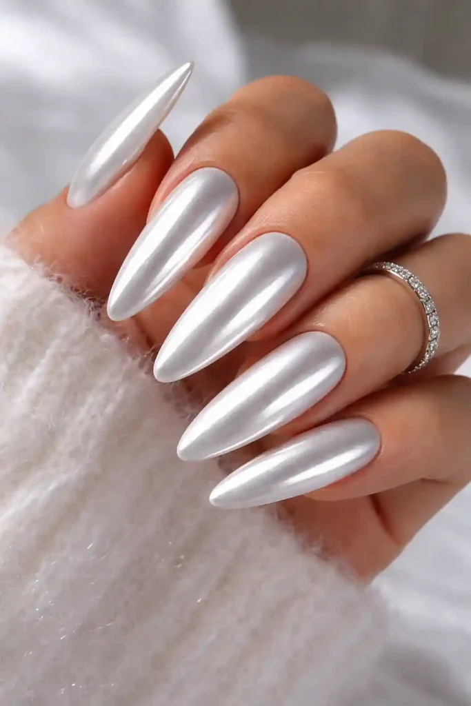 White chrome nails with a mirror-like reflective finish on long almond nails