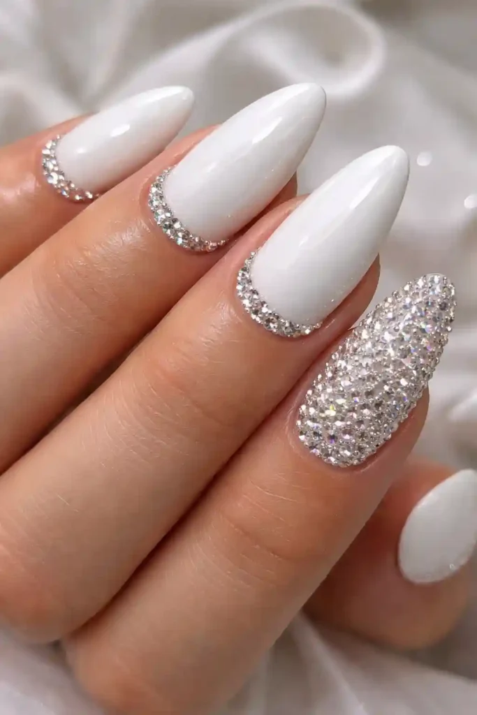 White nails with rhinestone crystal gems along the cuticle line on glossy white nails
