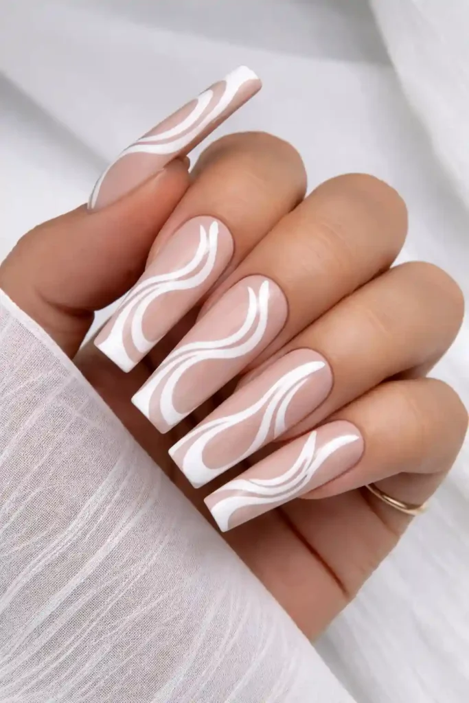 White swirl nails with hand-painted fluid swirl designs on long coffin nails