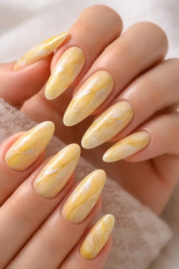 Yellow marble nails with gold veining
