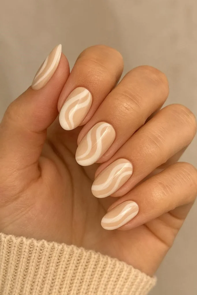 Beige and white swirl nails with a soft neutral marble effect