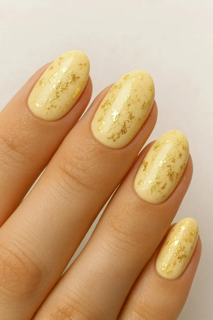 Butter yellow nails with gold foil accent details
