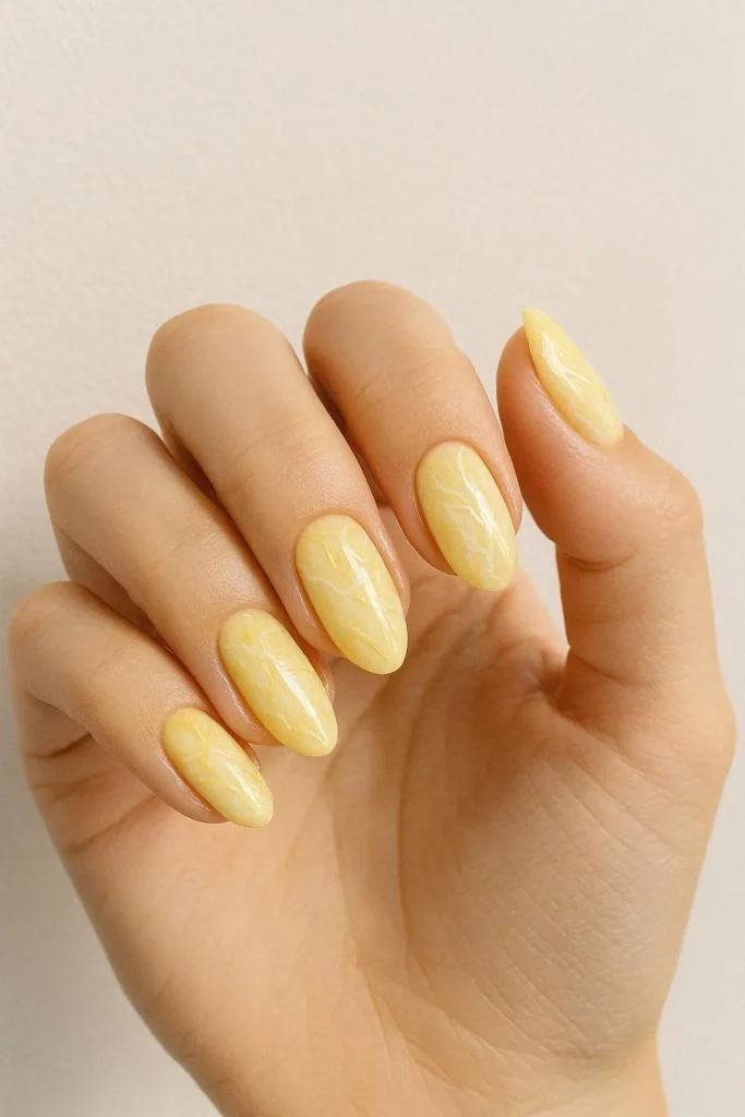 Butter yellow marble nails with white and gold veining 