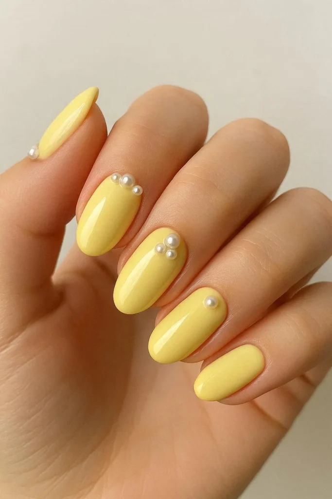 Butter yellow nails with small pearl accent details 