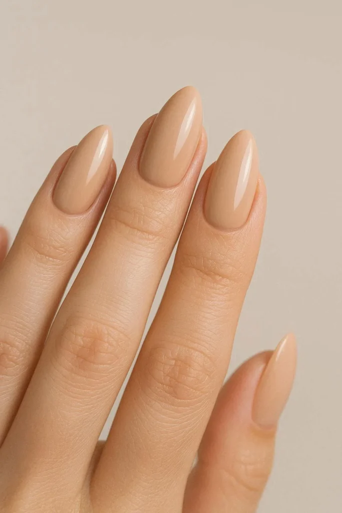 Clean almond shaped nude nails with a glossy finish