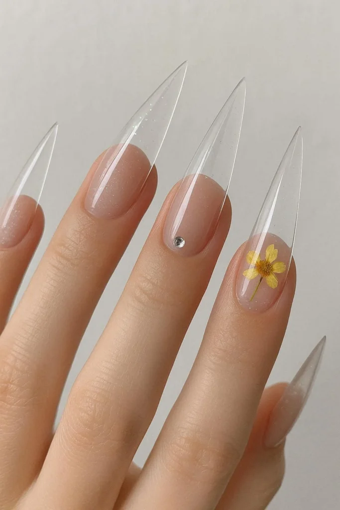 Clear acrylic stiletto nails with transparent base and subtle accents
