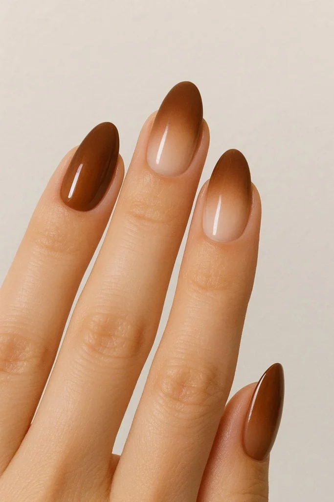 Earthy ombre nails blending warm brown into a soft nude
