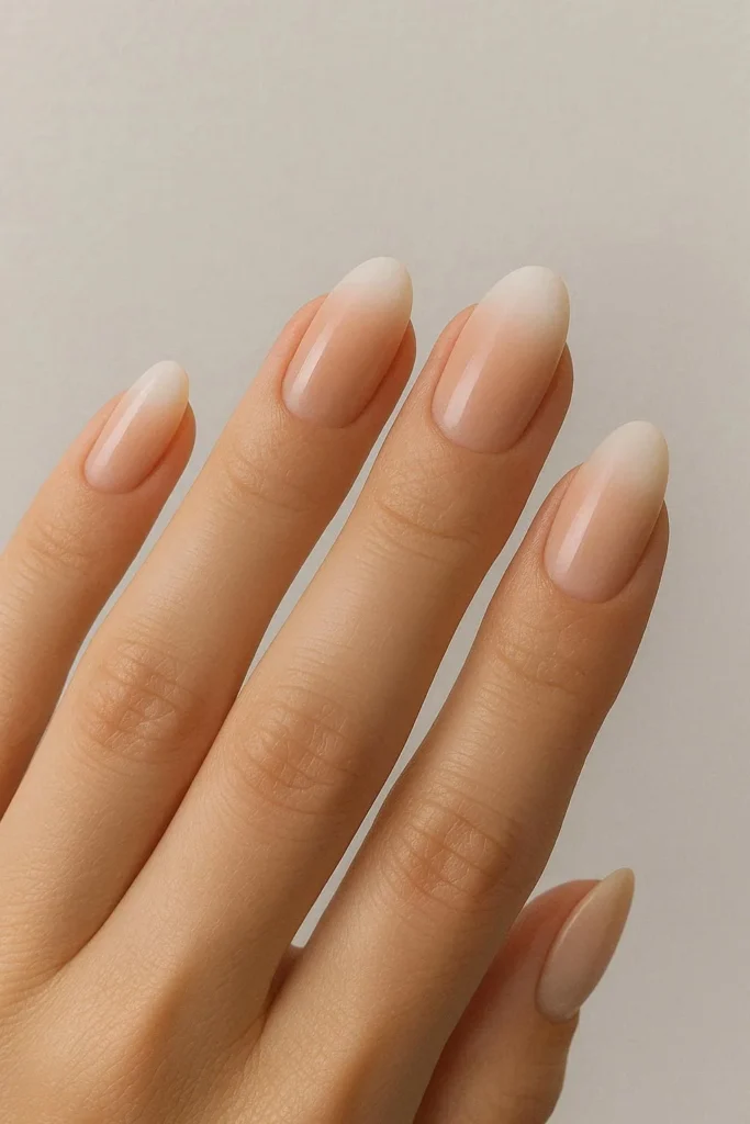 Neutral ombre nails fading from nude to soft white