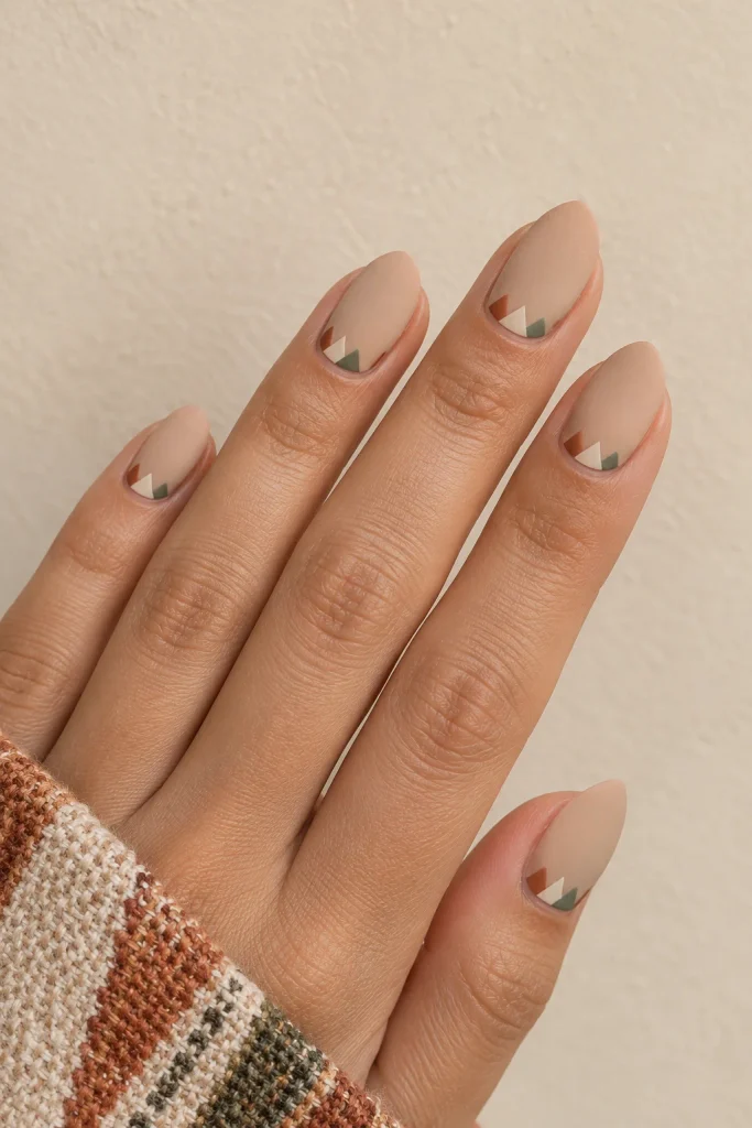 Short almond nails with terracotta cream and sage geometric triangles