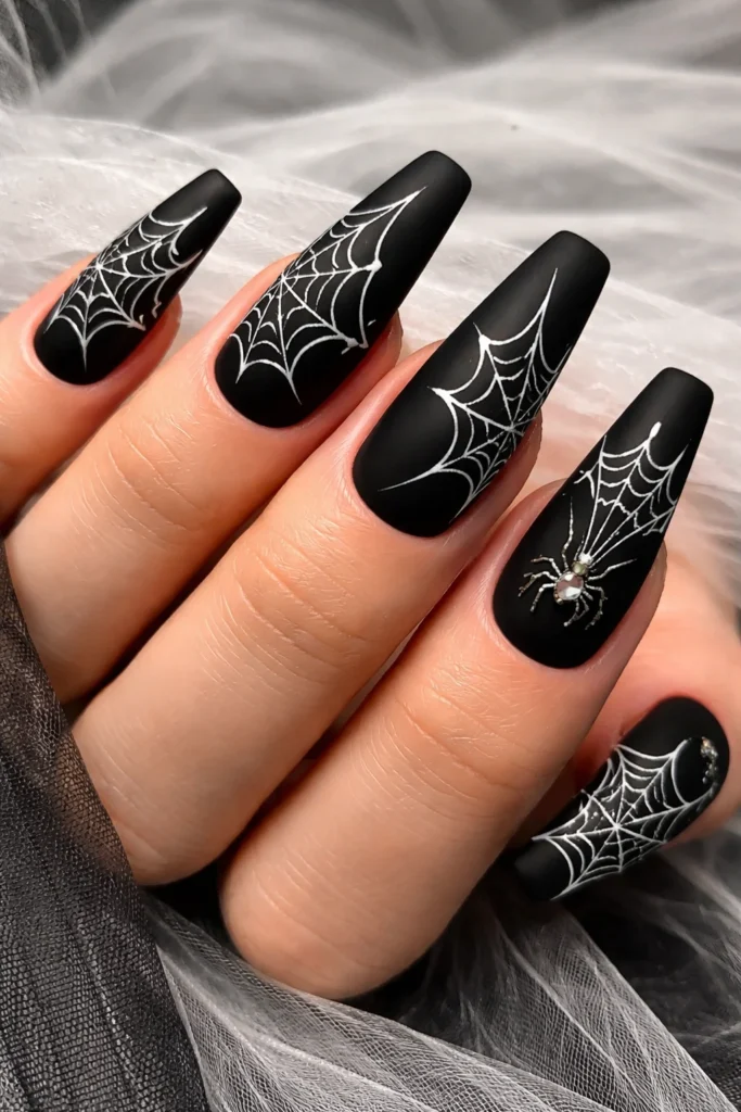 Black nails with white spider web Halloween nail art