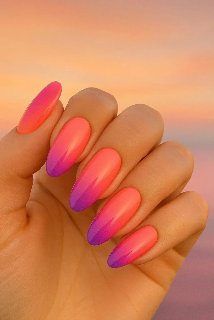 Sunset ombre beach nails in coral orange pink and purple gradient