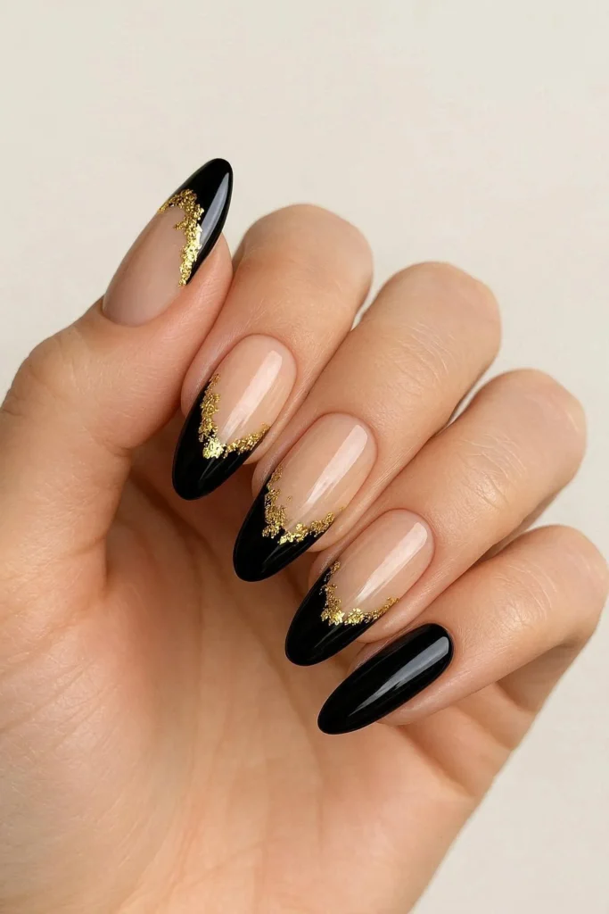 Black French tip nails with gold foil accents