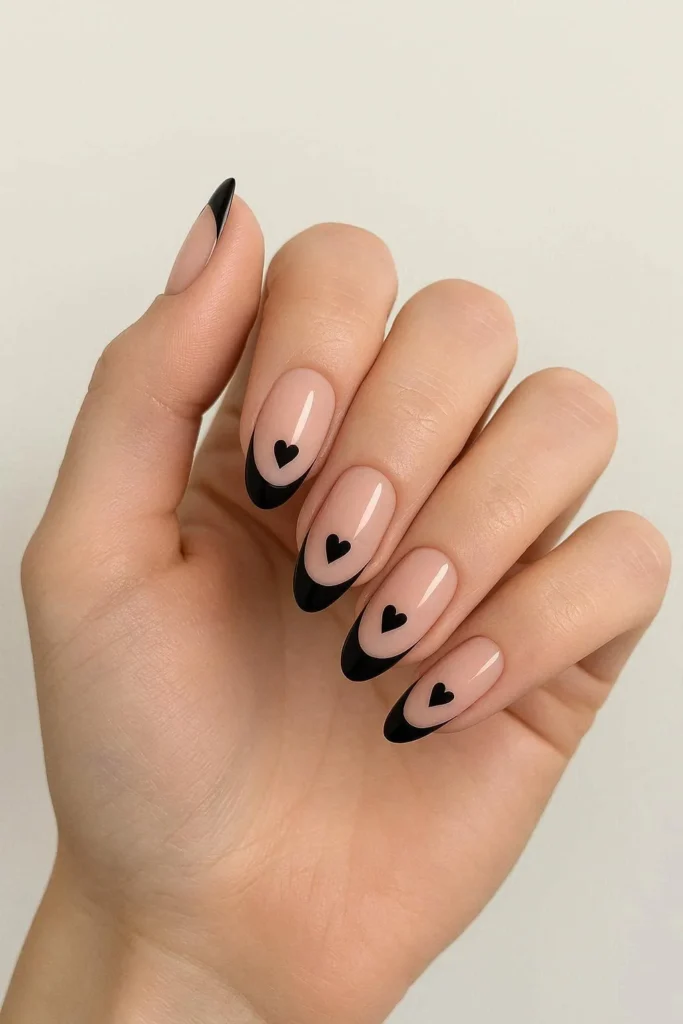 Black French tip nails with tiny painted heart accents