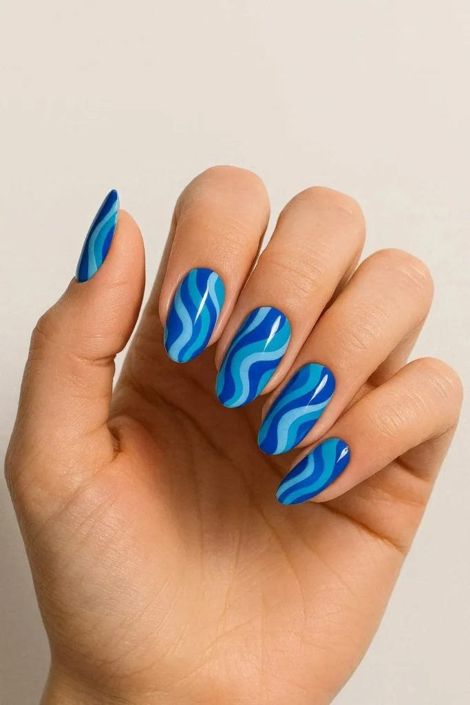 Blue retro swirl nails in ocean-inspired abstract pattern