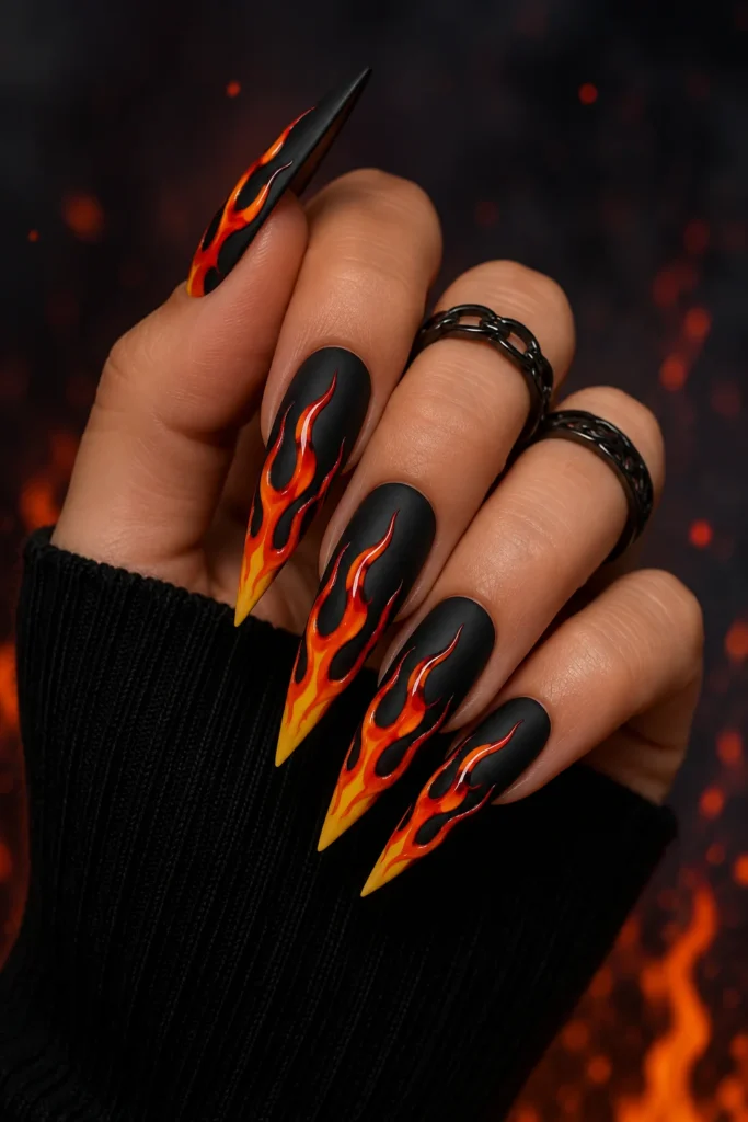 Funky flame nails in neon orange and yellow on black stiletto shape