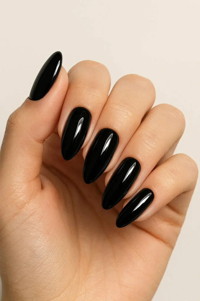 Sleek glossy black nails with bold modern manicure style