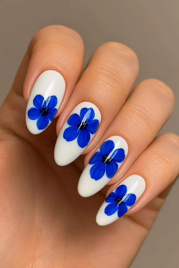 Tag: Glossy white nails with bold blue flower nail design 