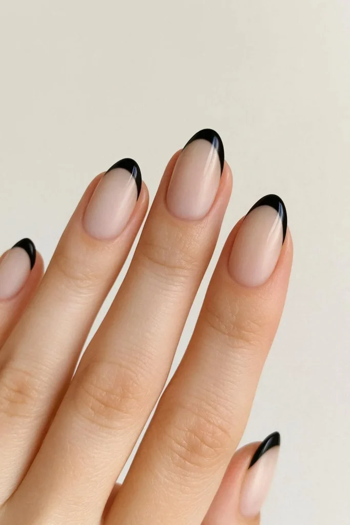 Milky nude base with bold black French tip nails