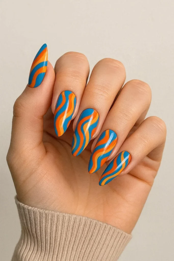 Orange and blue pucci nails with high-contrast retro swirl design