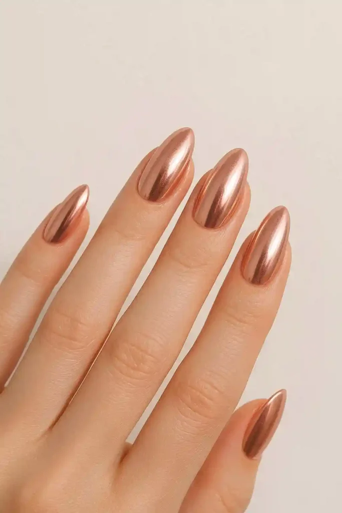 Rose gold chrome nails with warm reflective metallic finish