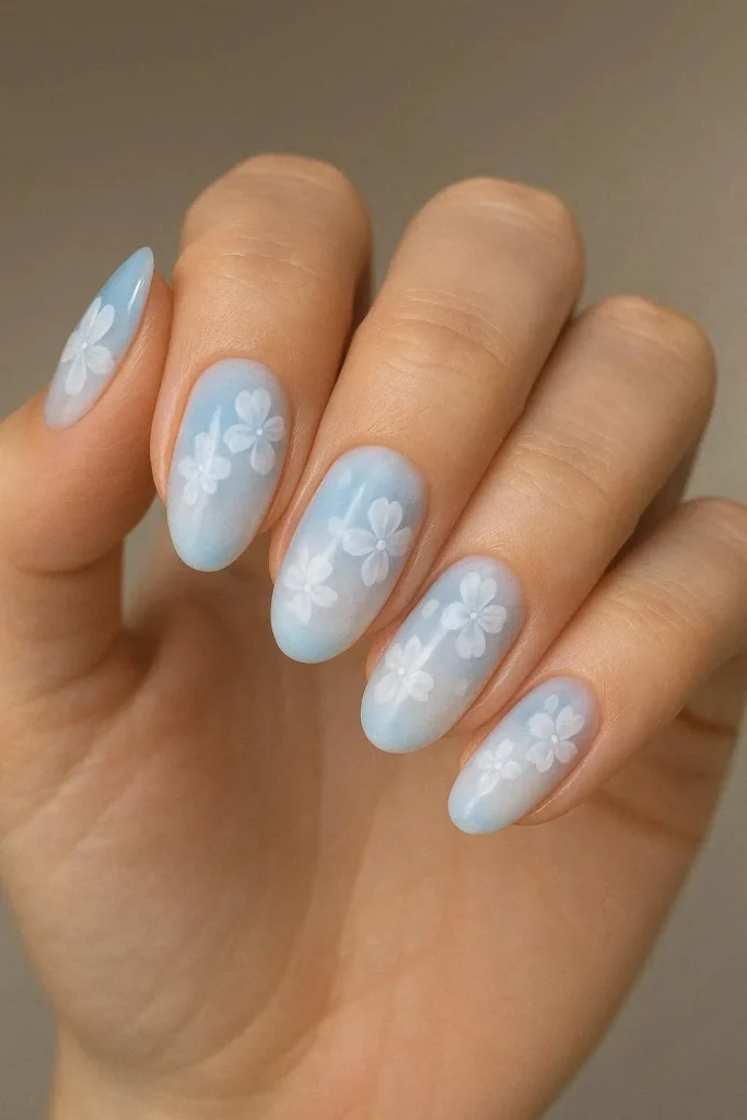 Soft blue to white ombre nails with floral accents