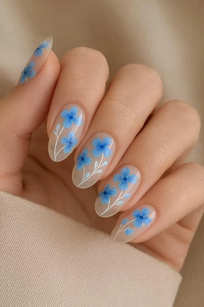 Transparent clear base nails with floating blue flower design 