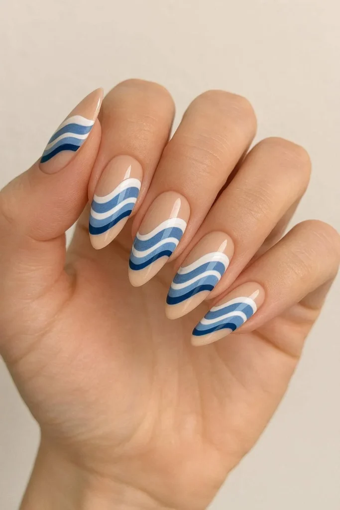 Wave pattern almond nails with blue and white flowing ocean designs