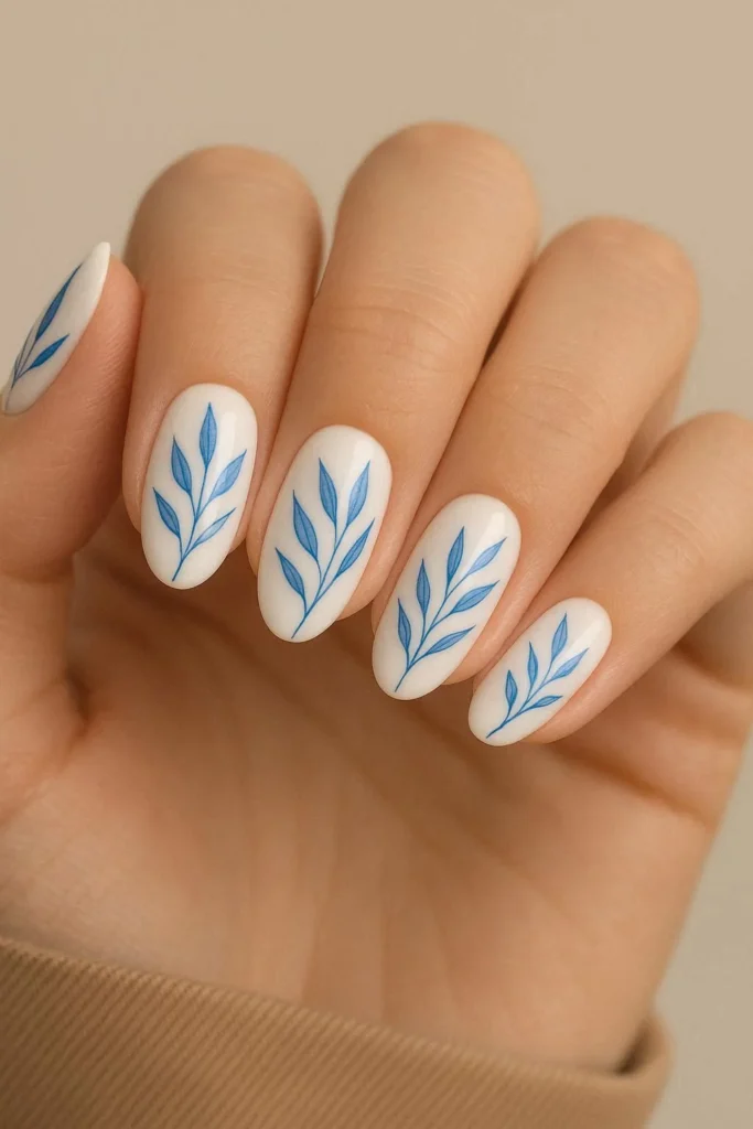  White nails with delicate blue botanical leaf nail design