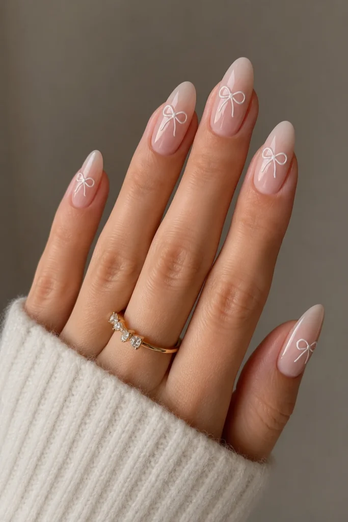 Elegant almond shaped nails with dainty bow details