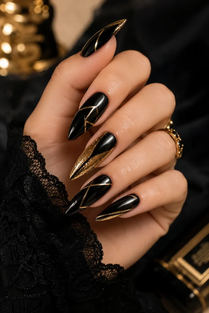 Glossy black nails with bold gold foil accent details
