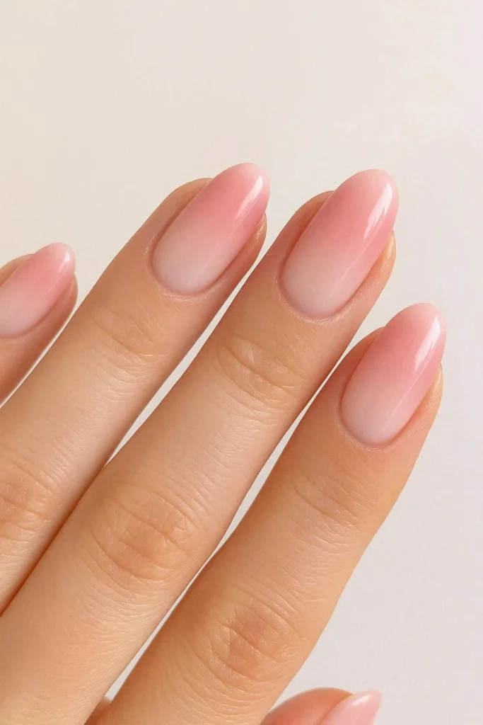 Blush pink ombre nails fading into milky white for winter