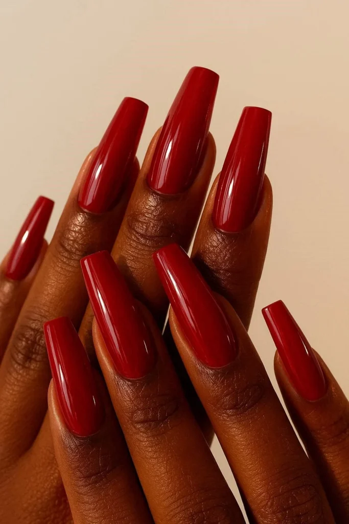 Vibrant cherry red glossy coffin nails on deep skin