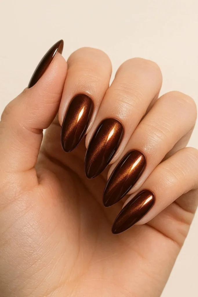 Chocolate brown cat eye nails with copper gold shimmer on almond shape