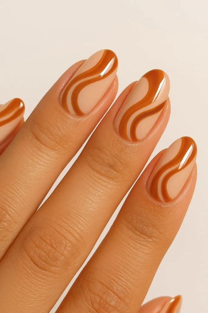 Classic caramel swirl nails on a creamy nude base