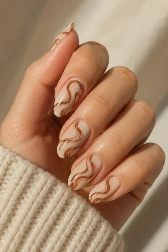 Classic cinnamon swirl nails on a creamy nude base